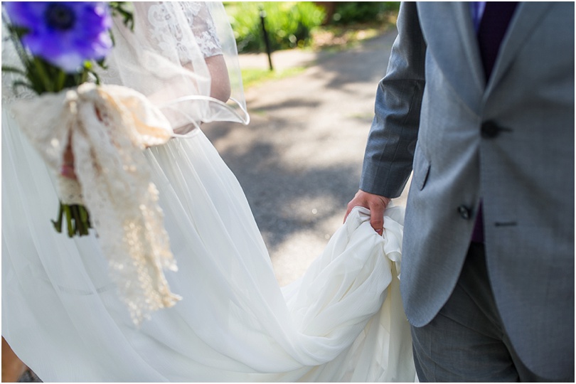 groom holding bride's dress