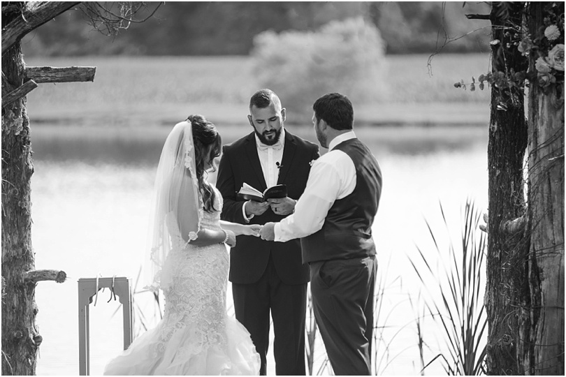bride and groom exchanging vows at summer wedding in the country